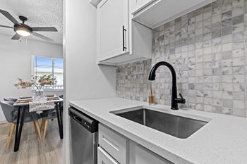 the kitchen and dining area of a house with a sink